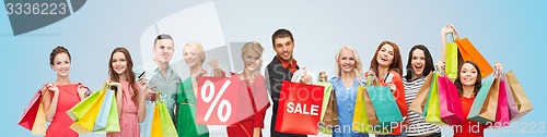 Image of happy people with sale sign on shopping bags
