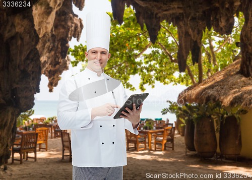 Image of happy male chef cook holding tablet pc