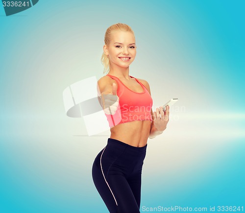 Image of smiling sporty woman with smartphone