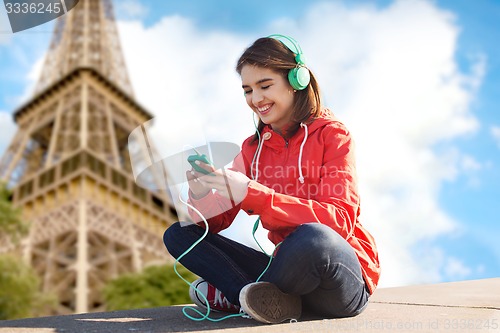 Image of happy young woman with smartphone and headphones