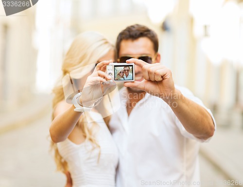 Image of travelling couple taking photo picture with camera