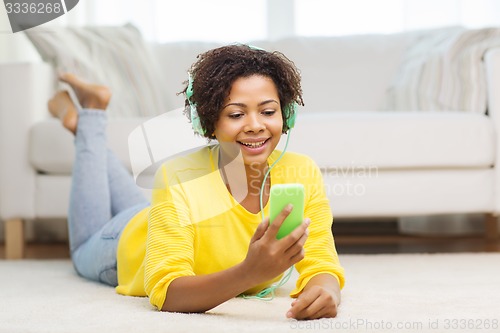 Image of happy african woman with smartphone and headphones