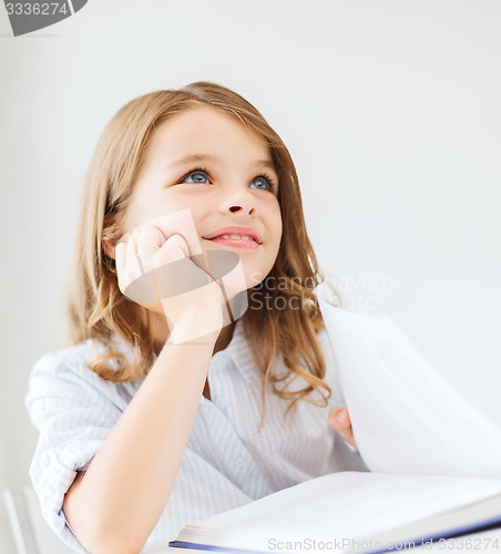 Image of student girl writing in notebook at school