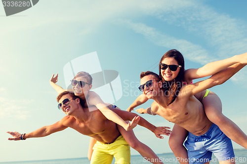 Image of smiling friends having fun on summer beach