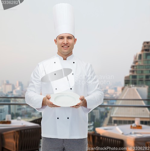 Image of happy male chef cook showing empty plate