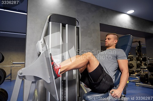 Image of man flexing leg muscles on gym machine