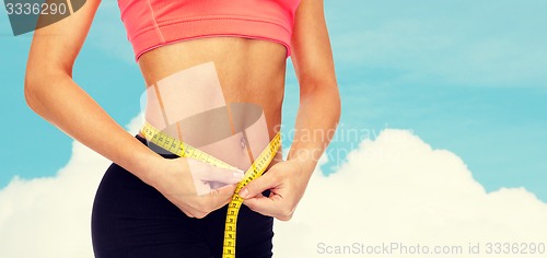 Image of close up of female hands measuring waist