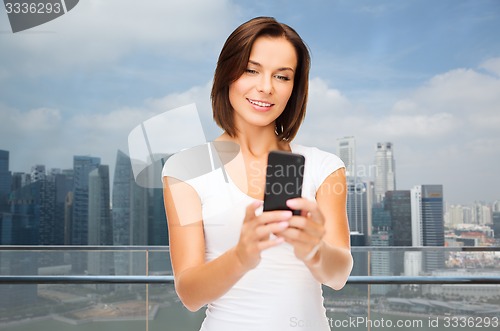 Image of woman taking selfie with smartphone over singapore
