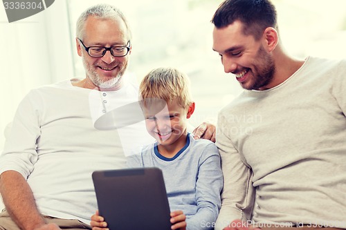 Image of smiling family with tablet pc at home