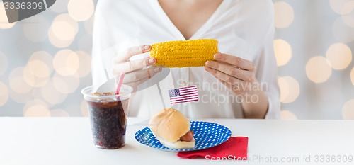 Image of woman hands holding corn with hot dog and cola