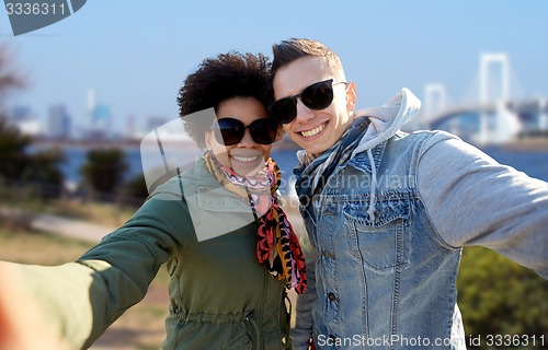 Image of happy teenage couple taking selfie in tokyo