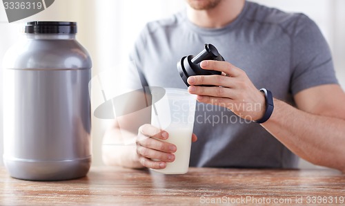 Image of close up of man with protein shake bottle and jar