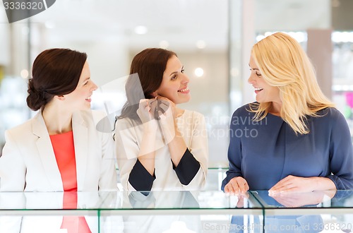 Image of happy women choosing earrings at jewelry store