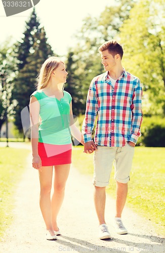 Image of smiling couple walking in park