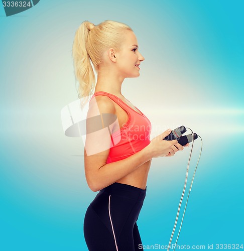 Image of smiling sporty woman with skipping rope