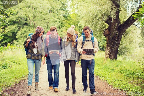 Image of group of friends with backpacks and tablet pc