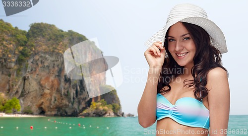 Image of happy young woman in bikini swimsuit and sun hat