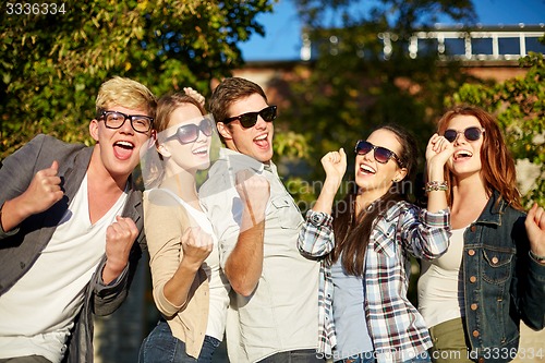 Image of group of happy friends showing triumph gesture