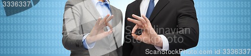 Image of businessman and businesswoman showing ok sign