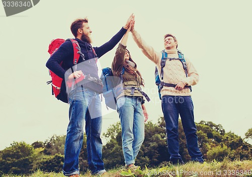 Image of group of smiling friends with backpacks hiking