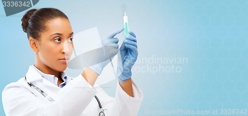Image of african doctor holding syringe with injection