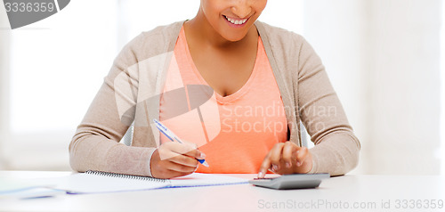 Image of businesswoman working with calculator in office