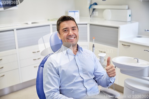 Image of happy man showing thumbs up at dental clinic