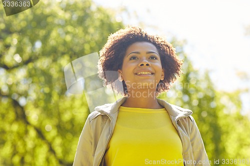 Image of happy african american young woman in summer park