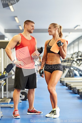 Image of smiling man and woman talking in gym