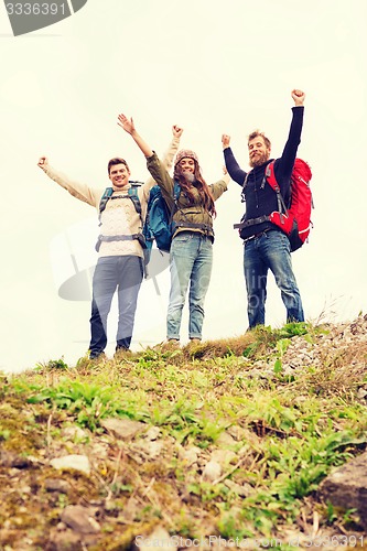 Image of group of smiling friends with backpacks hiking