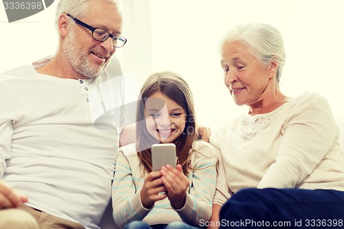 Image of smiling family with smartphone at home