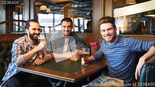 Image of happy male friends drinking beer at bar or pub