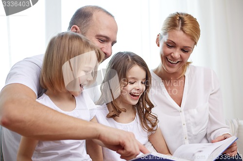 Image of happy family with book at home