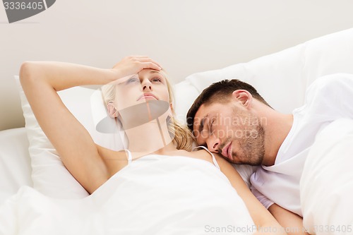 Image of couple sleeping in bed at home