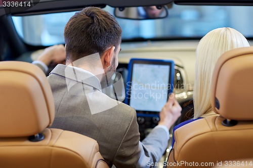 Image of couple sitting in cabriolet car with tablet pc