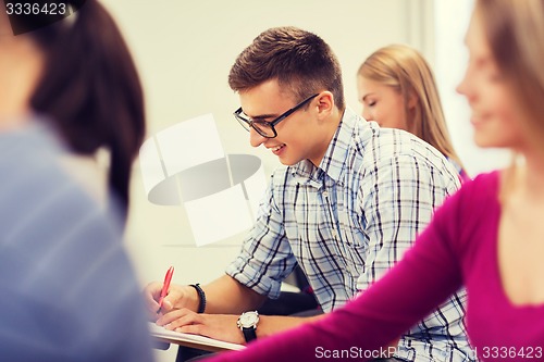 Image of group of smiling students with notebook