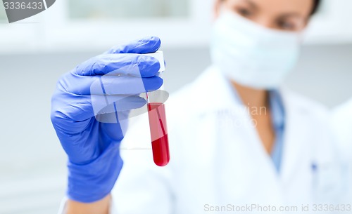 Image of close up of scientist holding test tube in lab