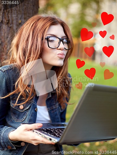 Image of happy student girl writing to notebook at campus