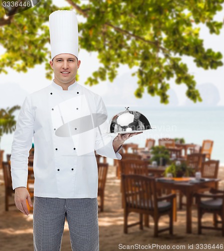 Image of happy male chef cook holding cloche