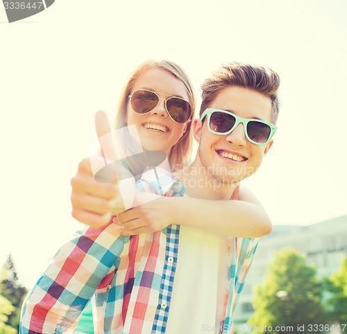 Image of smiling couple having fun and showing thumbs up