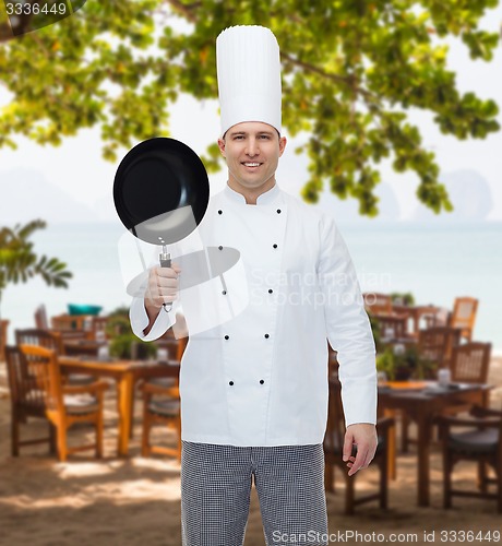 Image of happy male chef cook holding frying pan
