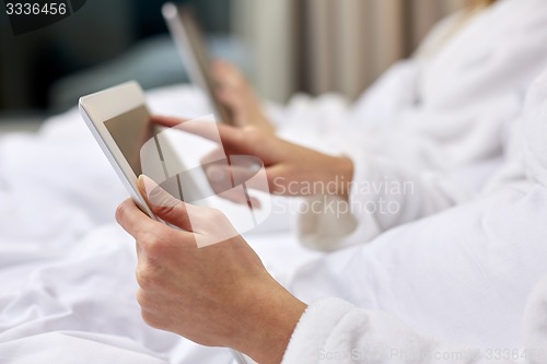 Image of close up of woman hands in bathrobe with tablet pc
