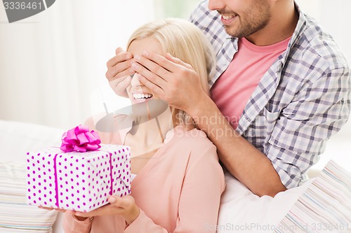 Image of happy man giving woman gift box at home