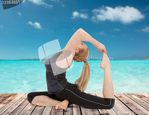 Image of happy young woman doing yoga exercise