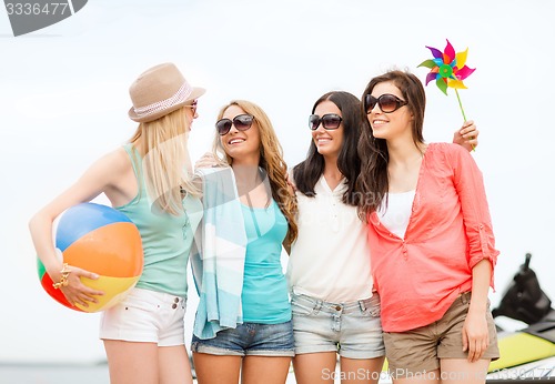 Image of smiling girls in shades having fun on the beach