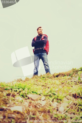 Image of smiling man with backpack hiking