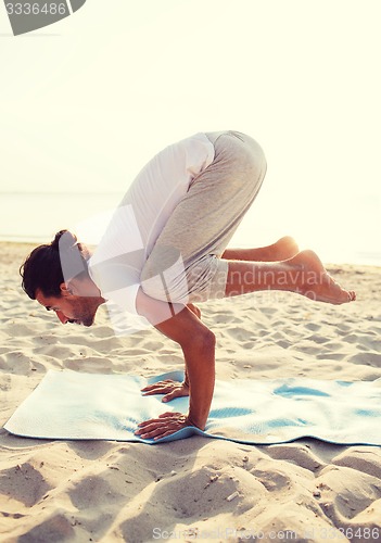 Image of man doing yoga exercises outdoors