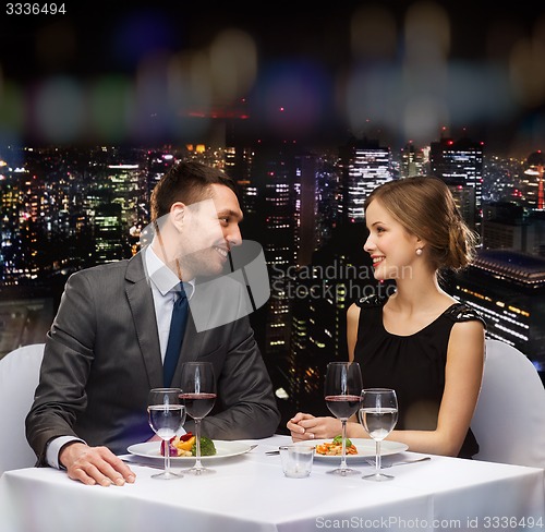 Image of smiling couple eating main course at restaurant