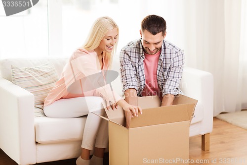 Image of happy couple with cardboard box or parcel at home