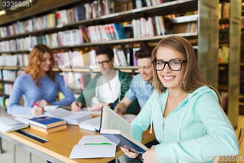 Image of happy students reading books in library